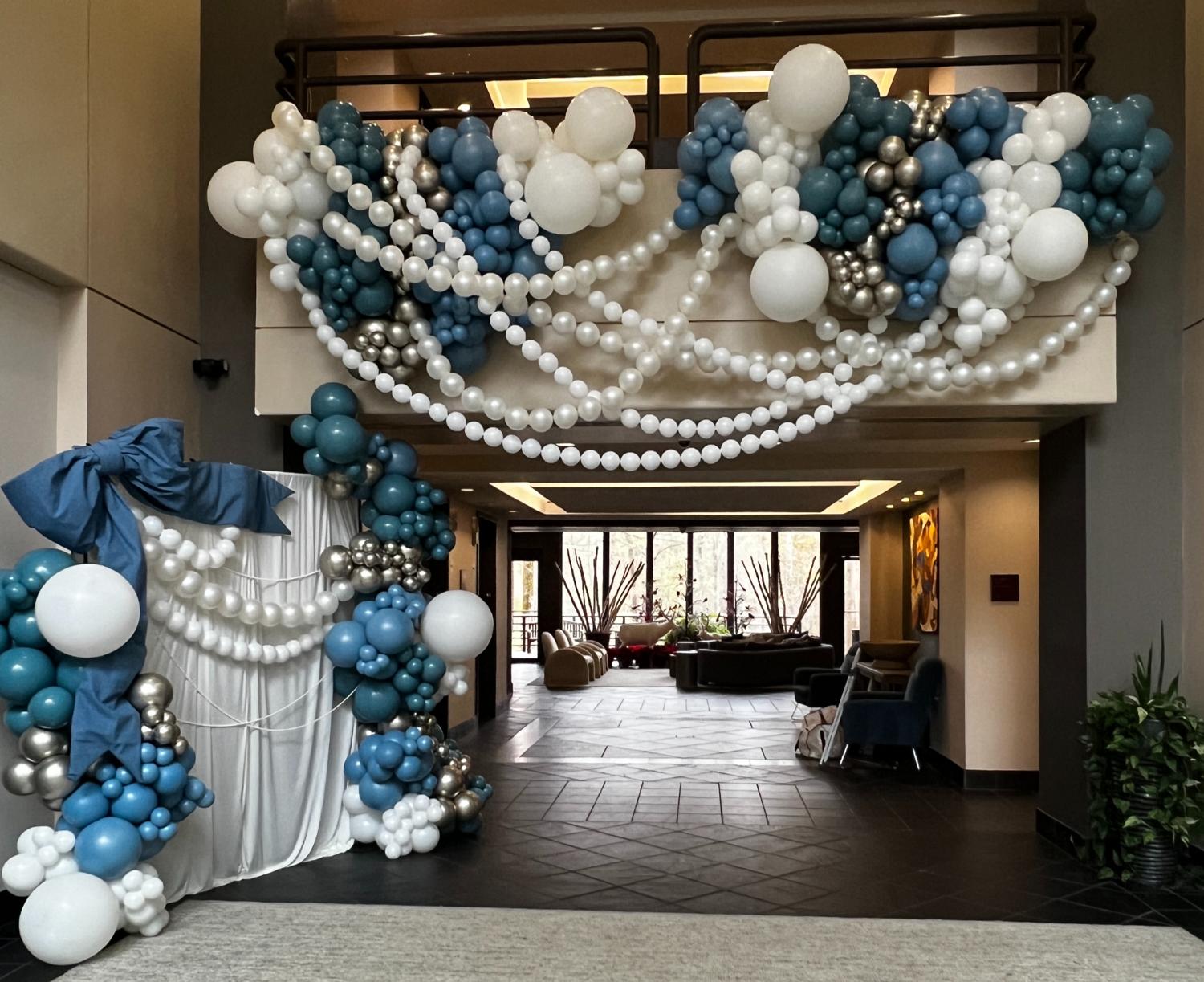 Blue and white custom balloon installation framing an event entrance